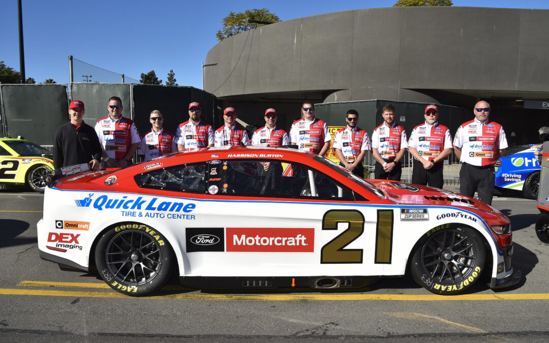 NASCAR team standing behind car