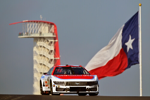 Number 21 car in the foreground with the Texas flag flying in the background