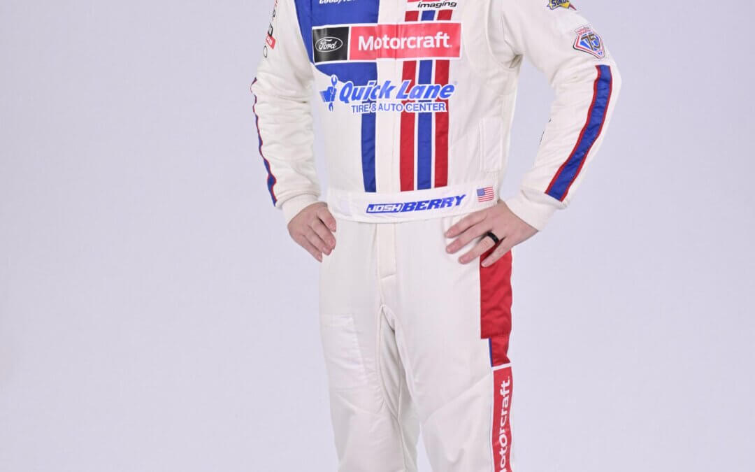 Josh Berry standing in full suit and a baseball cap for a photoshoot