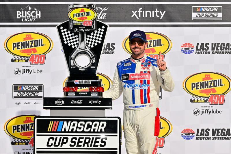 Josh Berry standing next to cup trophy