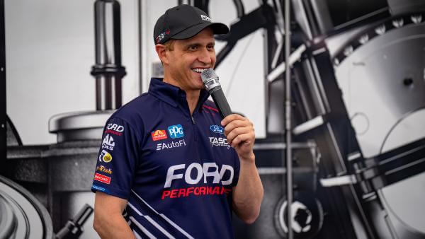 Tasca smiling and speaking into a microphone