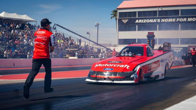 NHRA with man standing in front preparing for the race to start