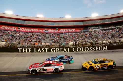 Wide angle shot of Number 21 car and others on track with a view of the crowd