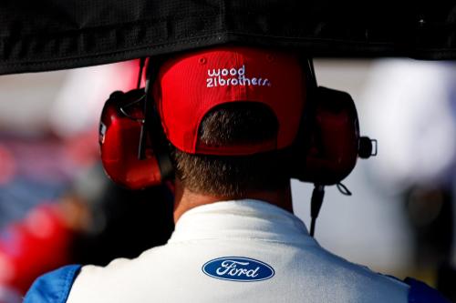 back view of someone wearing a headset and a wood brothers hat