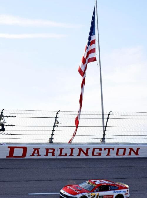Number 21 car on track at Darlington with an American flag in the background
