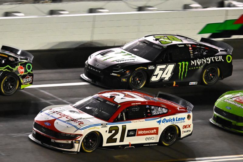 Side view of multiple Cars including number 21 on track