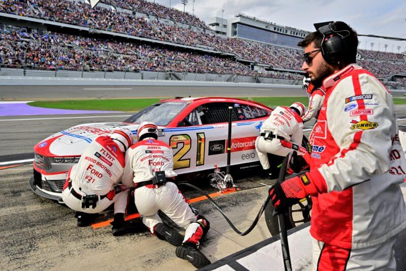 Pit crew working on the front driver tire