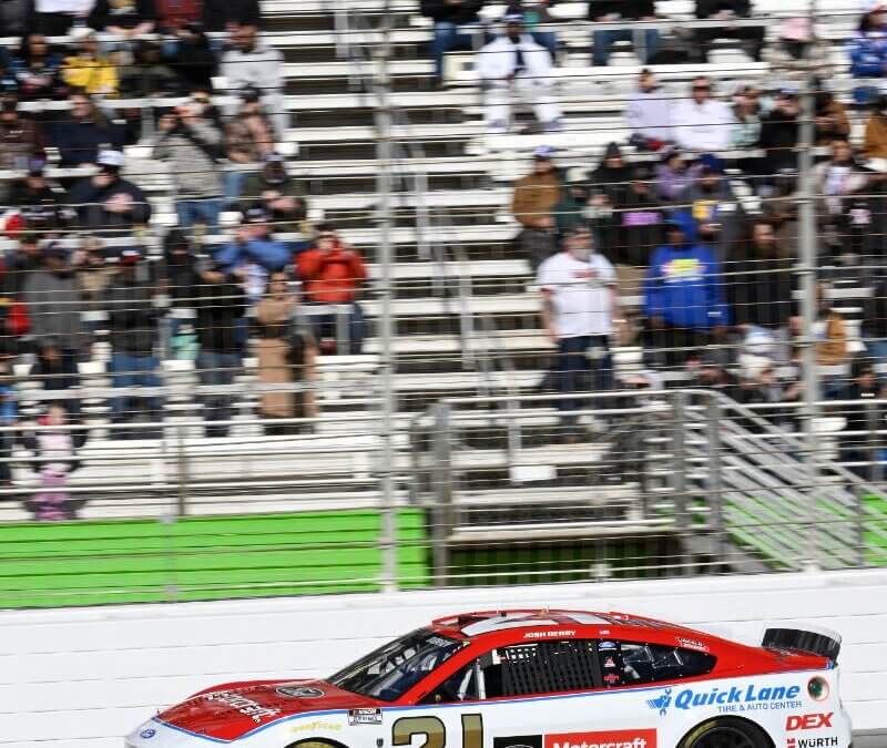 Portrait view of the number 21 car on track with full bleachers in the background