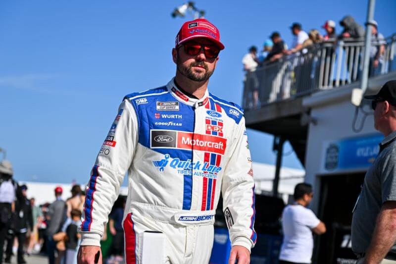 Candid picture of Josh Berry with sunglasses and a hat on walking at the track