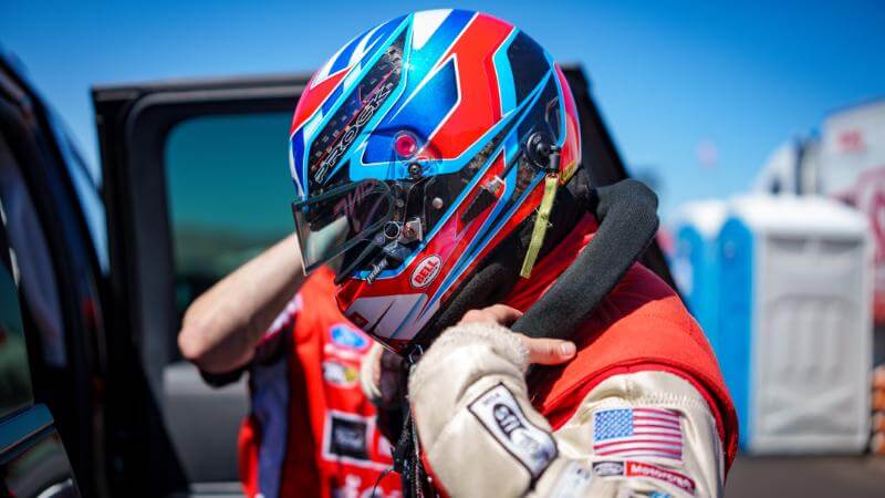 Prock putting a blue and red helmet on